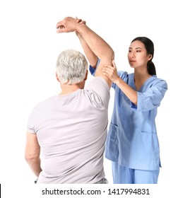 Young Asian Physiotherapist Working With Mature Man On White Background