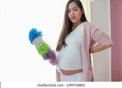 Young Asian Pregnant Woman Having A Back Pain While Doing Housework At Home. Pregnancy Housewife