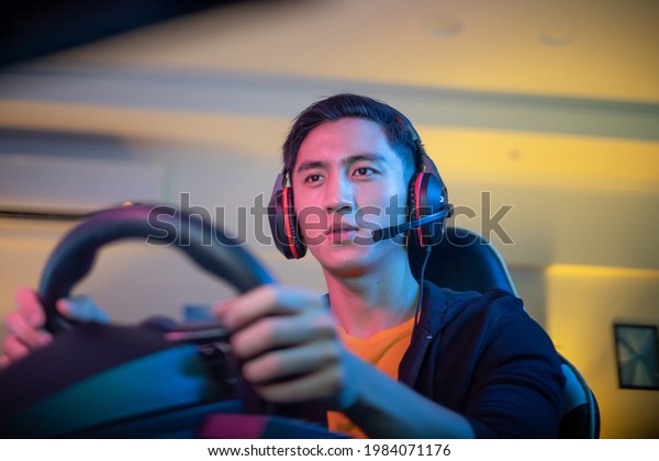 Young Asian Pro Gamer Man Play Car Racing Online\
Video Game