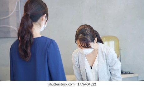 Young Asian Receptionist Talking With Customers With Surgical Mask. Hotel Worker. Store Clerk.