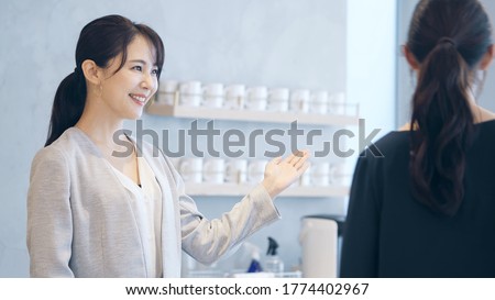 Young asian receptionist talking with customers. Hotel worker. Store clerk.