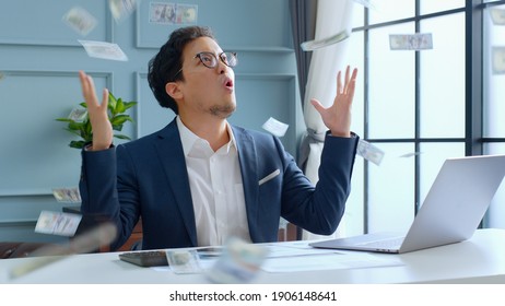 Young Asian Rich Businessman Enjoy With Money Rain While Working In Office, Millionaire Concept