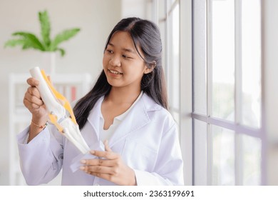 Young Asian roleplay as doctor standing happy smiling in school lab with space for text - Powered by Shutterstock