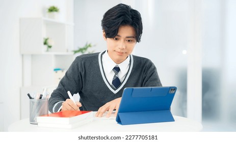 Young Asian schoolboy studying with a tablet PC. Online class. e-learning. - Powered by Shutterstock