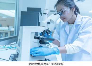 Young Asian Scientist Looking Through A Microscope In A Laboratory.Thailand People Doing Some Research.