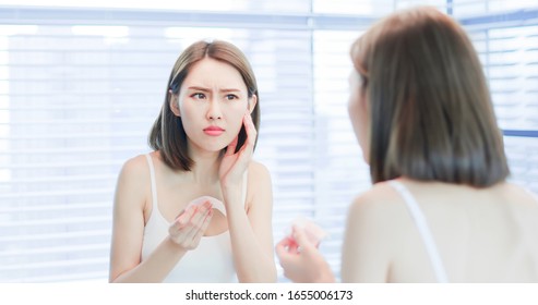 Young asian skin care woman upset after use oil blotting paper on her face