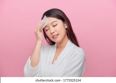 Young asian skin care woman smile and use oil blotting paper on her face