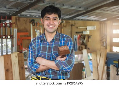 Young Asian Small Business Owner In The Woodwork Workshop And Calling On Phone With Customer.