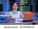 young Asian software development manager leads a late-night office discussion with his executive team, mentoring developers and analyzing source code to guide programming and project development