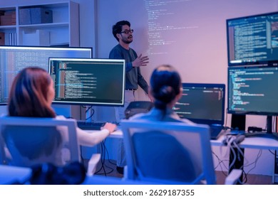young Asian software development manager leads a late-night office discussion with his executive team, mentoring developers and analyzing source code to guide programming and project development