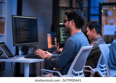 young Asian software development manager leads a late-night office discussion with his executive team, mentoring developers and analyzing source code to guide programming and project development