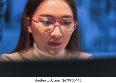 young Asian software development manager leads a late-night office discussion with his executive team, mentoring developers and analyzing source code to guide programming and project development