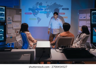 young Asian software development manager leads a late-night office discussion with his executive team, mentoring developers and analyzing source code to guide programming and project development	