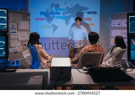 young Asian software development manager leads a late-night office discussion with his executive team, mentoring developers and analyzing source code to guide programming and project development	