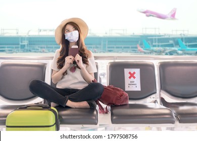 Young Asian Student College Girl Sitting At Airport Terminal Wear Medical Mask Feeling Happy With Safety Travel Bubble Plan After Covid Pandemic And Waiting For Flight In Fit To Fly In Asia Concept.