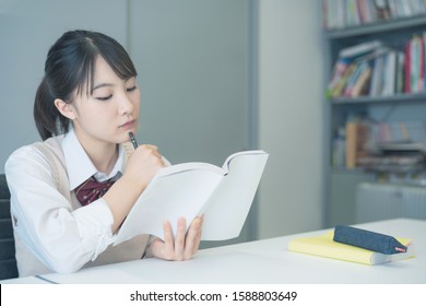 Young asian student studying in room. - Shutterstock ID 1588803649