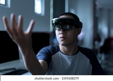 Young Asian Student Trying Mixed Reality With VR Glasses In The Laboratory. Gesture Of Men When Using Virtual Reality Headset