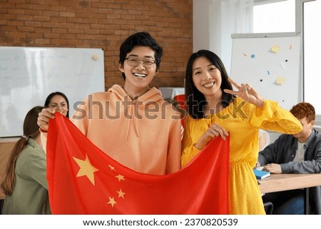 Young Asian students with Chinese flag at language school