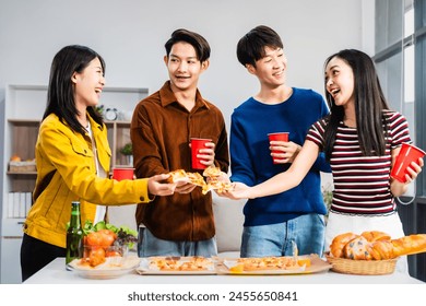 
Young Asian students gather with friends for a pizza party, laughing and sharing slices. Enjoying fast food delivery, they embody diversity and togetherness in a relaxed, enjoyable lifestyle. - Powered by Shutterstock