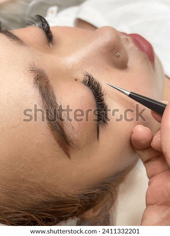 Young Asian teenage girl doing fashionable orange hairstyle Both beautiful and cute like dolls. Currently receiving eyelash extension services by a beauty expert in the salon. or beauty salon