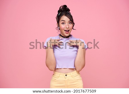 Young Asian teenage girl surprised excited isolated on pink background.	