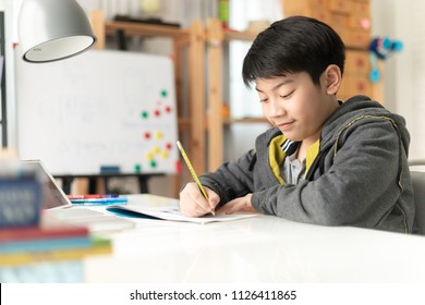 Young asian teenage student doing homework at home