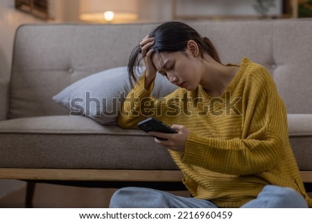 Young asian teenager woman feeling bored or Sad while playing smartphone at university, life concept