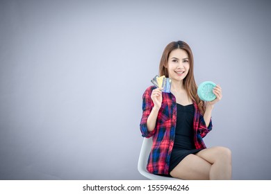 Young Asian Thai woman use a mobile phone to do online shoping with a credit card at home