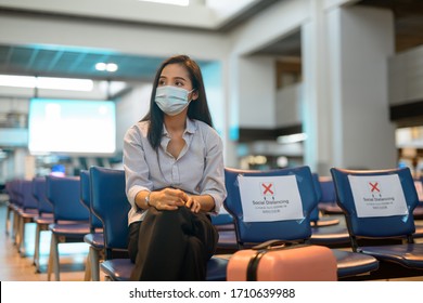 Young Asian tourist woman with mask thinking and sitting with distance at the airport