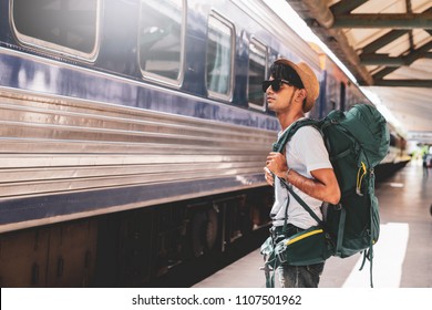 Young Asian Traveler With Backpack In The Railway, Backpack And Hat At The Train Station With A Traveler, Travel Concept