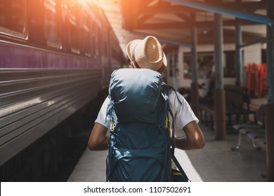 Young asian traveler with backpack in the railway, Backpack and hat at the train station with a traveler, Travel concept