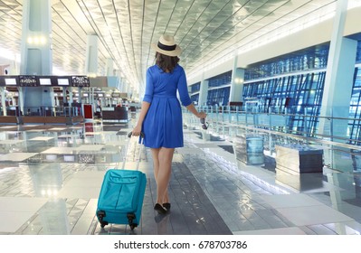 Young Asian Traveler Wearing Hat Carrying Suitcase In The Airport