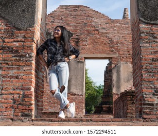 Young Asian trendy social lifestyle influencer girl standing next to wall smiling - Female travel blogger reviewing interesting destinations and places - Traveller, hipster and location trends concept