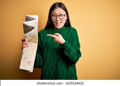 Young Asian Turist Woman Looking At City Tourist Map On A Trip Over Yellow Background Very Happy Pointing With Hand And Finger