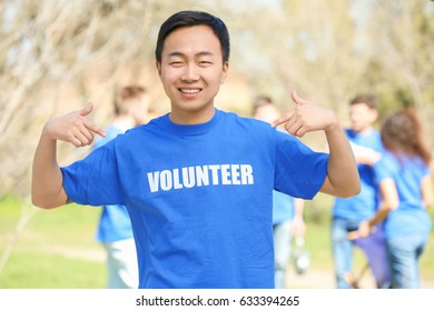 Young Asian Volunteer With Team Outdoors