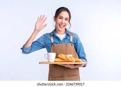 young asian waitress barista wearing apron hand hold bread and coffee drink on wooden tray smiling warm welcome invite customer to her coffee shop studio shot on white background - Powered by Shutterstock