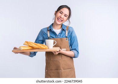 young asian waitress barista wearing apron hand hold bread and coffee drink on wooden tray smiling warm welcome invite customer to her coffee shop studio shot on white background - Powered by Shutterstock