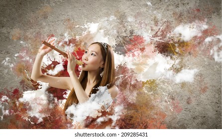 Junge asiatische Frau auf buntem Hintergrund beim Spielen von fiebern