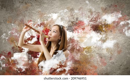 Junge asiatische Frau auf buntem Hintergrund beim Spielen von fiebern