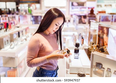 Young Asian Woman Applying And Choose To Buy Perfume In Duty Free Store At International Airport.