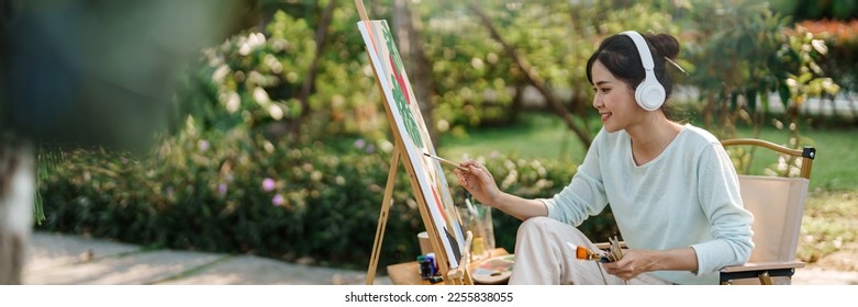 Young asian woman artist painting on canvas.
Female artist drawing with inspiration in garden - Powered by Shutterstock