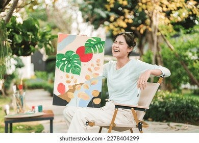 Young asian woman artist painting on canvas.
Female artist drawing with inspiration in garden - Powered by Shutterstock