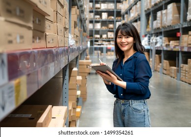 Young Asian Woman Auditor Or Trainee Staff Work Looking Up And Checks The Number Of Items Store By Digital Tablet. Asian Owner Or Small Business Concept.