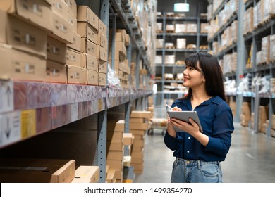 Young Asian Woman Auditor Or Trainee Staff Work Looking Up And Checks The Number Of Items Store By Digital Tablet. Asian Owner Or Small Business Concept.