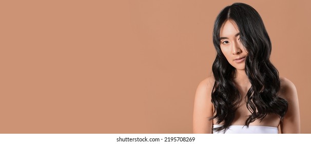 Young Asian Woman With Beautiful Long Wavy Hair On Beige Background With Space For Text