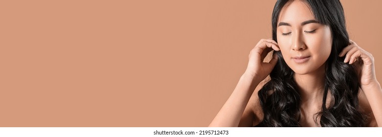 Young Asian Woman With Beautiful Long Wavy Hair On Beige Background With Space For Text