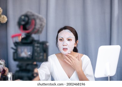 Young Asian woman beauty blogger or vlogger recording review product facial sheet mask for face skincare to share on social media.