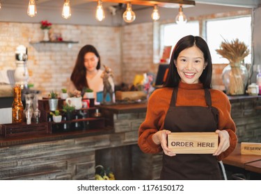 Young Asian Woman Business Owner At Front Of Cafe/bar/restaurant/coffee And Bakery Shop