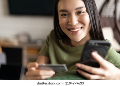 Young Asian Woman Buying From Online Shop, Using Mobile Phone And Credit Card, Shopping From Home