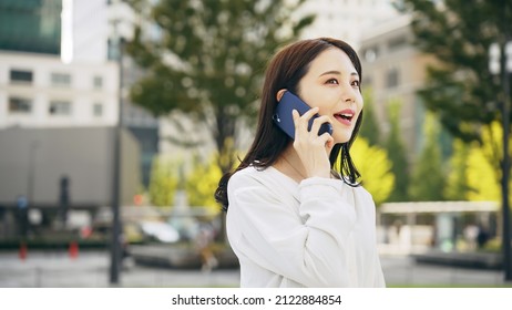 Young Asian Woman Calling With A Smart Phone In The City.